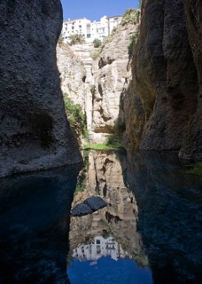 El Tajo canyon of the Rio Guadalevin river with white buildings perched on the cliff top, Ronda,
