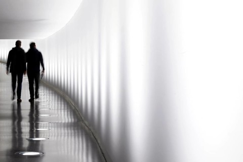 Members of the German Bundestag walk through a tunnel. The tunnel connects the Reichstag and the