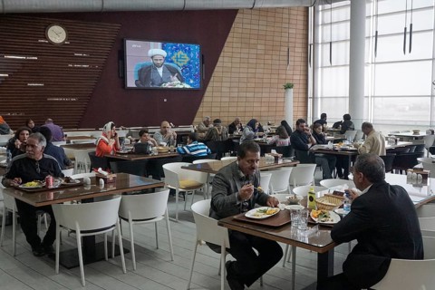 A mullah is seen on a large screen in a modern restaurant at a motorway service station, 13.03.2019