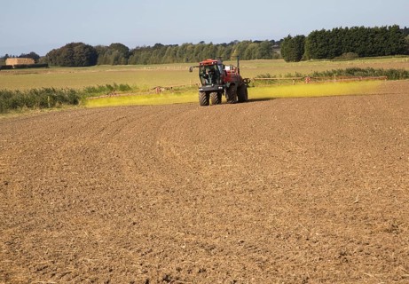 Farm machinery spraying Glyphosate herbicide on an arable field near Hollesley, Suffolk, England,