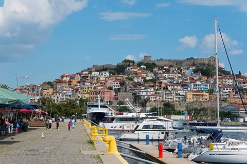 View of a lively harbour promenade with boats, people and a castle on a hill, fortress, old town,