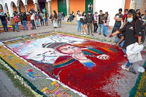 Peruvian woman making a floor painting in the Plaza de Armas, spectators watching, Ayacucho,