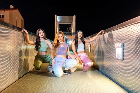 Frontal portrait of an alternative group of young and cool hip hop dancers posing on a bridge at