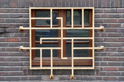 Lattice wooden window in Art Nouveau style, embedded in a brick wall