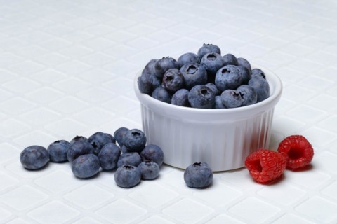 Blueberries in small bowls, raspberries