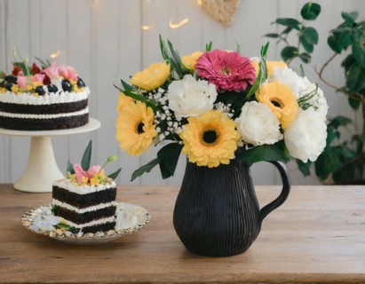 A vase full of flowers next to delicious-looking cakes on a white tablecloth, AI generated, AI