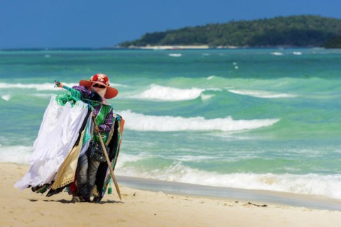 Trader on the beach selling clothes, sun protection, beach vendor, holiday, symbol, symbolic, sea,