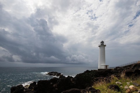 White lighthouse on a steep coast. Dramatic clouds with a view of the sea, pure Caribbean at Le