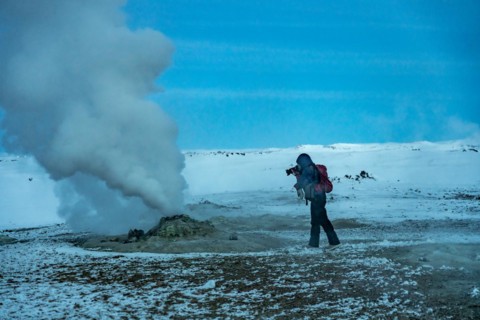 Adventurous photographer woman in winter in Iceland photographing in the Hverir or Namafjall