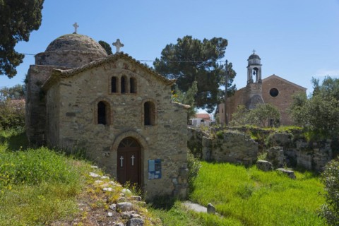 Ancient stone church surrounded by trees and vegetation, Temple of Apollo of ancient Assinai,