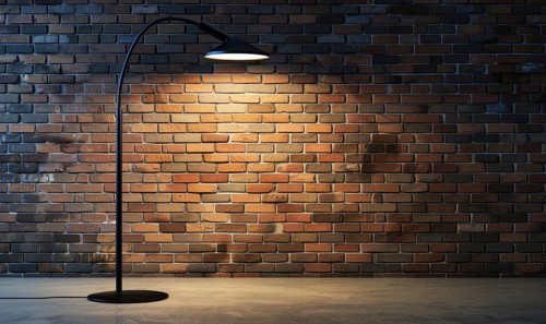 A modern arc floor lamp stands out against a brick wall, providing warm lighting in a sophisticated