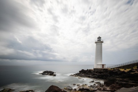 White lighthouse on a steep coast. Dramatic clouds with a view of the sea, pure Caribbean at Le