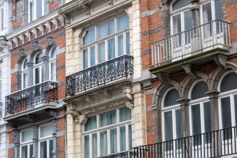 Historic building with elaborate brick facade and wrought-iron balcony, Blankenberge, Flanders,