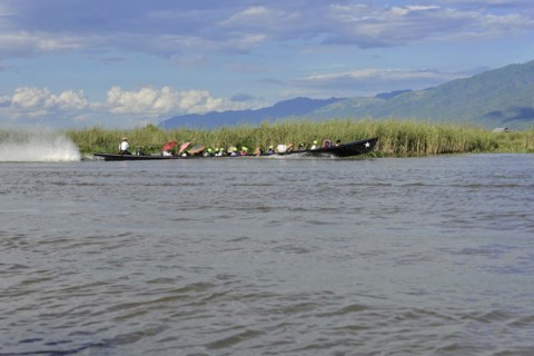 Group of people in a long boat on calm water, Inle Lake, Myanmar, Asia