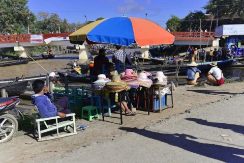 Colourful scene of a riverside street market with boats and people, Pindaya, Inle Lake, Myanmar,