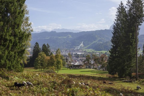 Overview of Garmisch-Partenkirchen with Karwendel mountains and forest in autumn, hiking trail