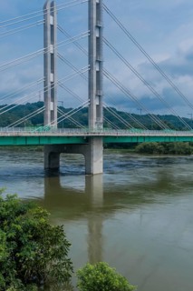 Tall suspension bridge over a river seen on a day with a cloudy sky, in South Korea