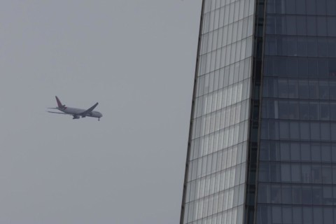 Aircraft of Air India airways in flight over The Shard city skyscraper building, London, England,