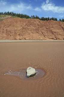 Erratic boulder on the beach at low tide, cliffs, red sandstone, Five Islands Provincial Park,
