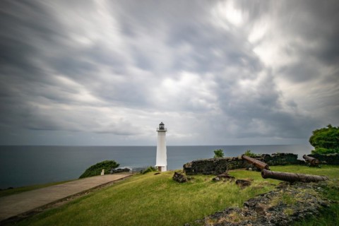 White lighthouse on a steep coast. Dramatic clouds with a view of the sea, pure Caribbean at Le