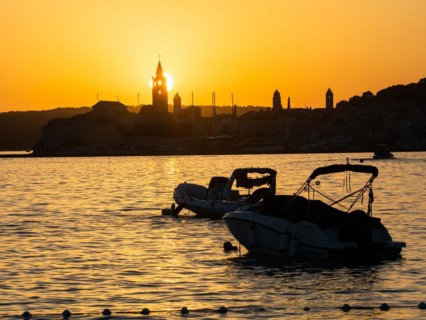 Boats anchoring in a bay, sunset, silhouette of the church towers of Rab, town of Rab, island of