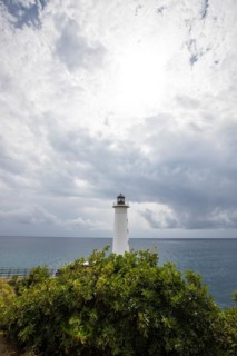 White lighthouse on a steep coast. Dramatic clouds with a view of the sea, pure Caribbean at Le