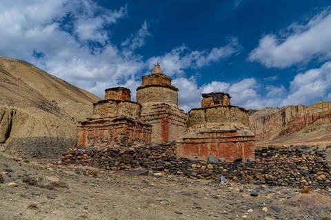 Colourfully painted Buddhist stupa, in a eroded mountain landscape, Kingdom of Mustang, Nepal, Asia