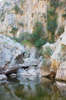 Torrent de Pareis, calm water surface in a riverbed of a mountain stream surrounded by impressive,