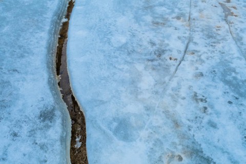 Texture of ice with a large crack on a frozen surface, in South Korea