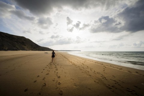 Young woman walking on the beach, emotion, rock, distance, cloudy, cloudy, mood, atmosphere, alone,