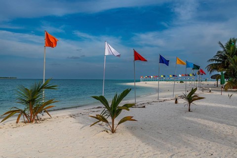 White sand beach with many flags, Bangaram island, Lakshadweep archipelago, Union territory of