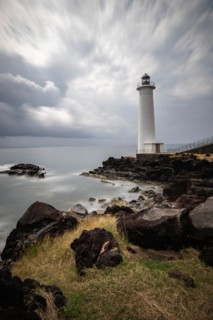 White lighthouse on a steep coast. Dramatic clouds with a view of the sea, pure Caribbean at Le