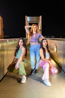 Vertical portrait of a group of three beauty young breakdancers posing together at night in a