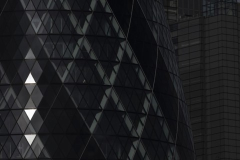 The Gherkin skyscraper building close up of window details with sunlight illuminating three