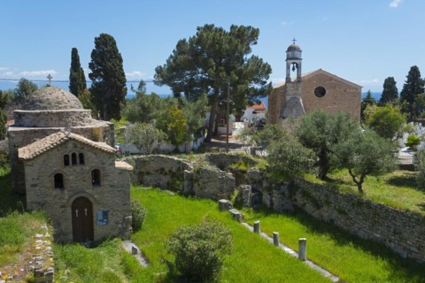 Old church surrounded by ruins in a rural area with tall cypress trees, Temple of Apollo of ancient
