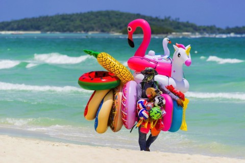 Merchant on the beach selling inflatable swimming aids, colourful, swimming, beach vendor, holiday,