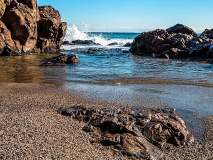Rocky shoreline with whitecaps on the sea under bright daylight, in South Korea