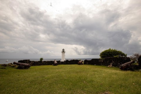 White lighthouse on a steep coast. Dramatic clouds with a view of the sea, pure Caribbean at Le