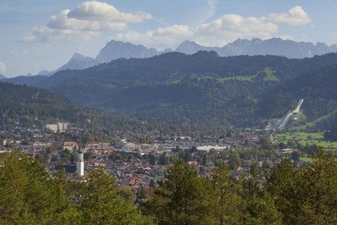 Overview of Garmisch-Partenkirchen with Karwendel mountains and forest in autumn, hiking trail