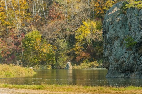 Tranquil view of a rock formation with trees in autumn colors reflecting in a lake, in South Korea