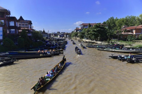 Lively river scene with boats and cityscape in the background, Pindaya, Inle Lake, Myanmar, Asia