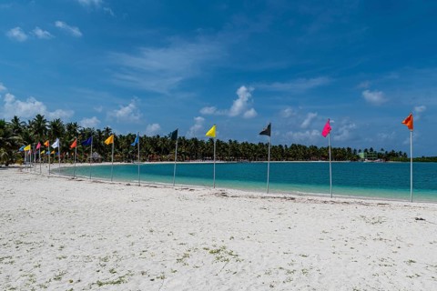 White sand beach with many flags, Bangaram island, Lakshadweep archipelago, Union territory of