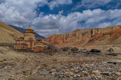 Colourfully painted Buddhist stupa, in a eroded mountain landscape, Kingdom of Mustang, Nepal, Asia