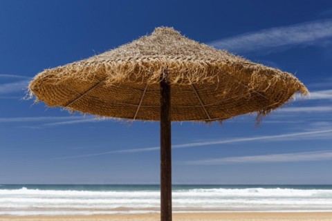 Parasol made of raffia on the beach with sea view, summer, sun, summer holiday, beach holiday,