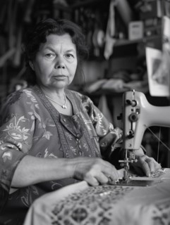 Focused woman using a sewing machine in a workshop, illustrating craftsmanship, AI generated