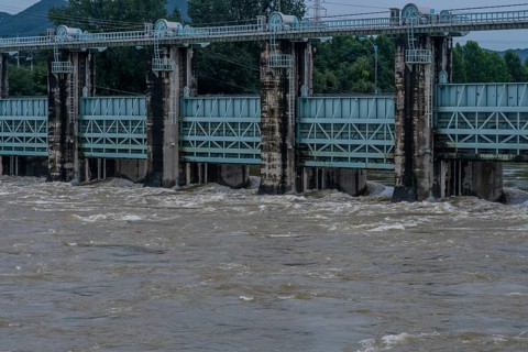 Dam with water surging through open floodgates after torrential monsoon rains in Daejeon South