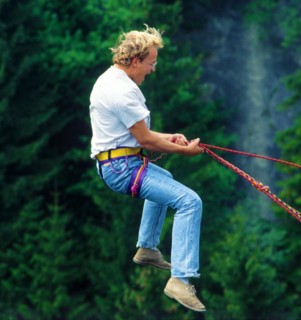 Man, about 24 years old, jumping on a climbing rope secured by the bridge, Echelsbacher Bridge,