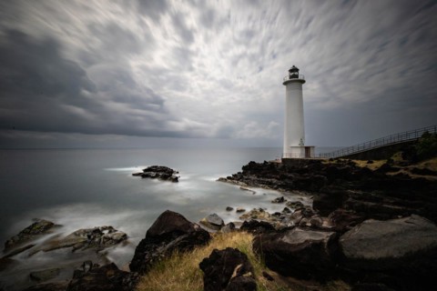 White lighthouse on a steep coast. Dramatic clouds with a view of the sea, pure Caribbean at Le