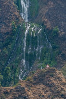Little stupa undeaneath a huge waterfall, along the highway to Jomsom, Nepal, Asia