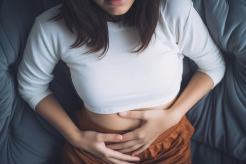 Woman in pain with stomach ache or menstrual cramps holding stomach with hands. KI generiert,